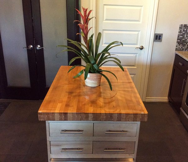 A wooden epoxy table top with a flower vase resting on the surface.