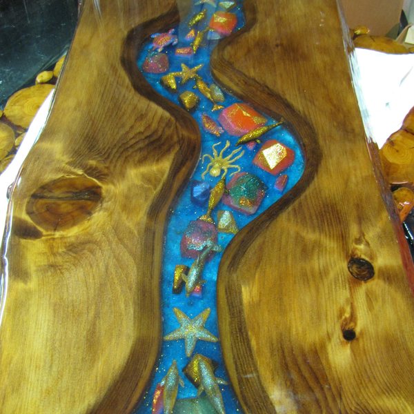 An epoxy river table with embedments and an aquatic nature theme.