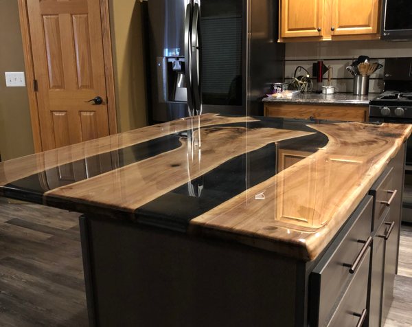 An epoxy river countertop, with two epoxy veins tinted black.