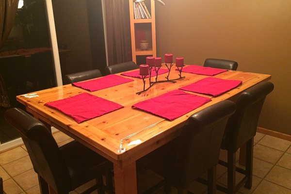 A rectangular wooden epoxy table top, surrounded by 6 chairs.