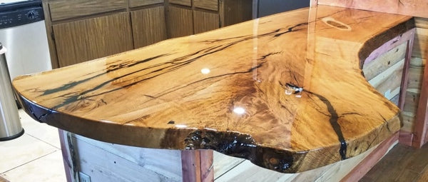 A live edge epoxy countertoptop with a table top epoxy flood coat