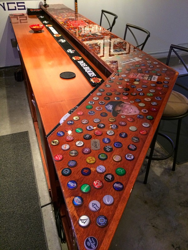 An indoor epoxy bottle cap bar top with additional embedded paraphernalia