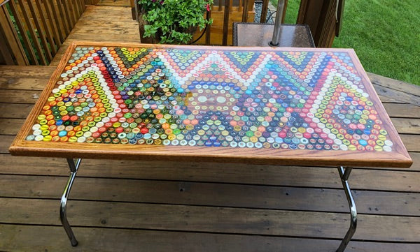 An outdoor epoxy bottle cap table top with a rectangular shape