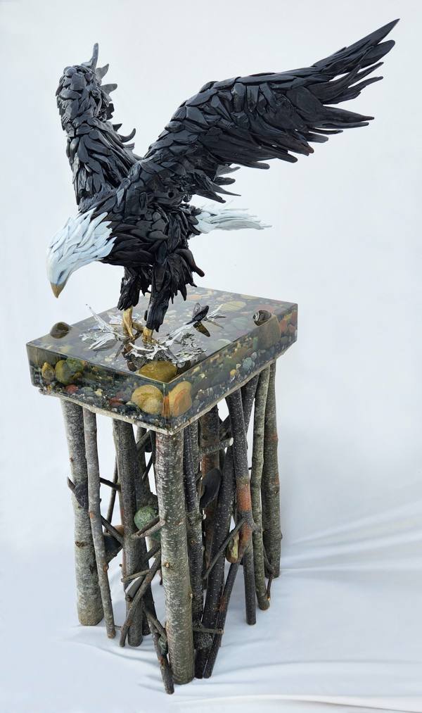 A epoxy sculpture of an eagle hunting for food in the water.