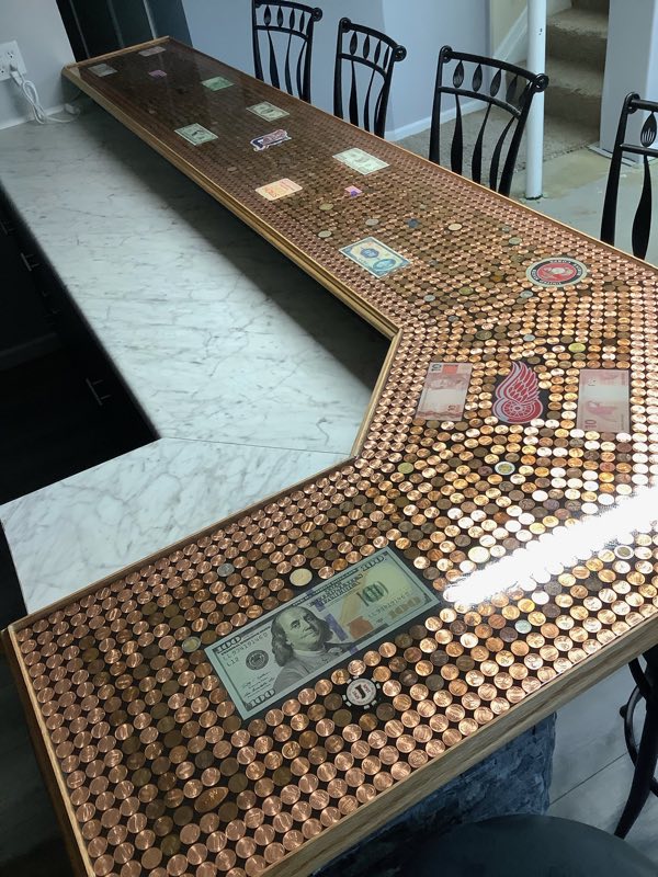 An epoxy penny bar top with additional mixed currency embedded within