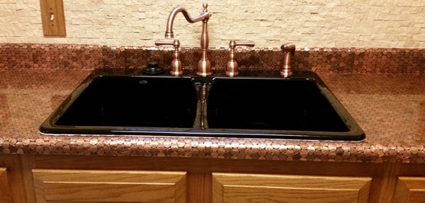 An epoxy penny countertop with a copper sink faucet