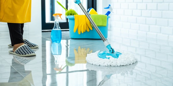 An epoxy floor being mopped with a suitable cleaner and a mop.