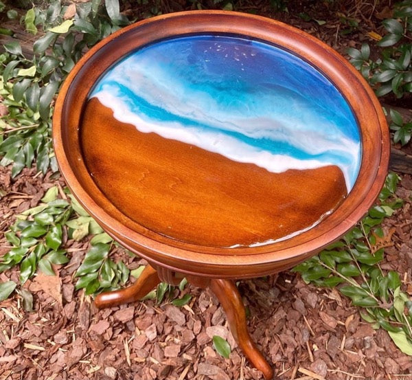A beach themed epoxy table top with wave patterns formed due to viscous resin.