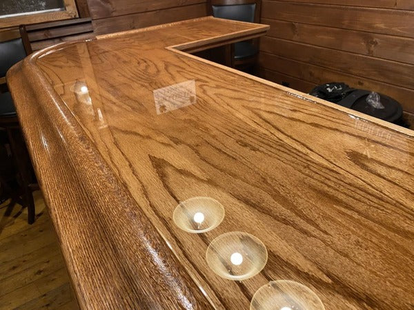 A high-trim wooden bar top with a coating of epoxy resin.