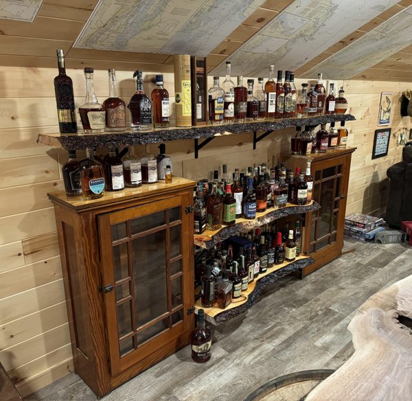 Shelves and furniture holding up a wide variety of alcoholic beverages.