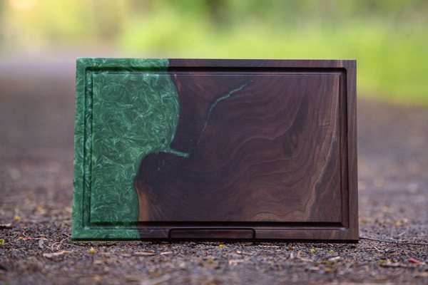 A wooden epoxy resin serving tray, resting in a stand.