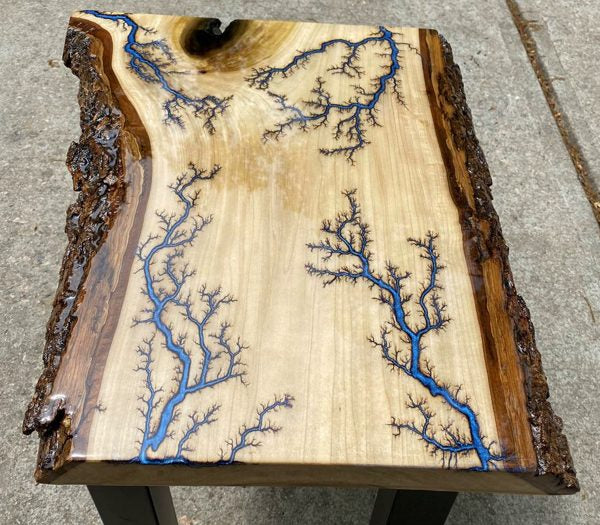 A live edge epoxy river table with branching blue veins
