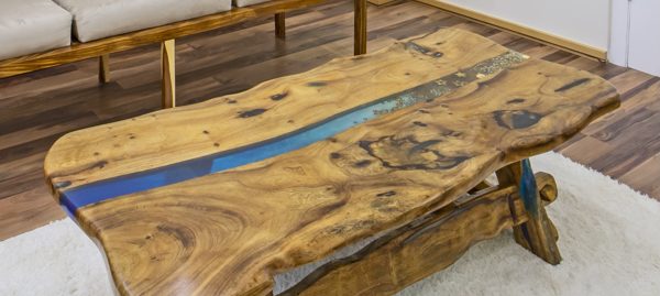 An epoxy river table with a wide blue gradient vein