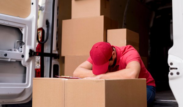 A tired delivery worker behind on his deliveries.