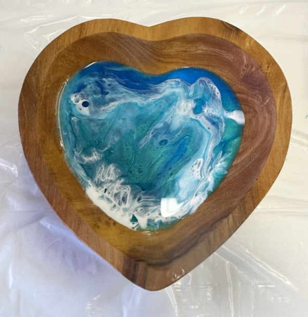 A wooden dish with an ocean resin art epoxy finish on the interior surface.