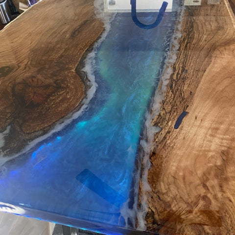 An epoxy river table with blue pigmentation