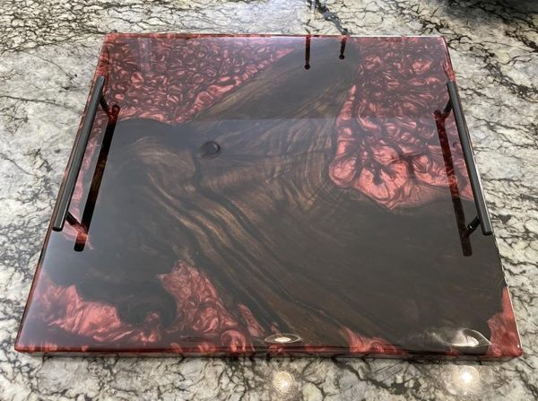 An epoxy resin tray made with wood and red-tinted epoxy