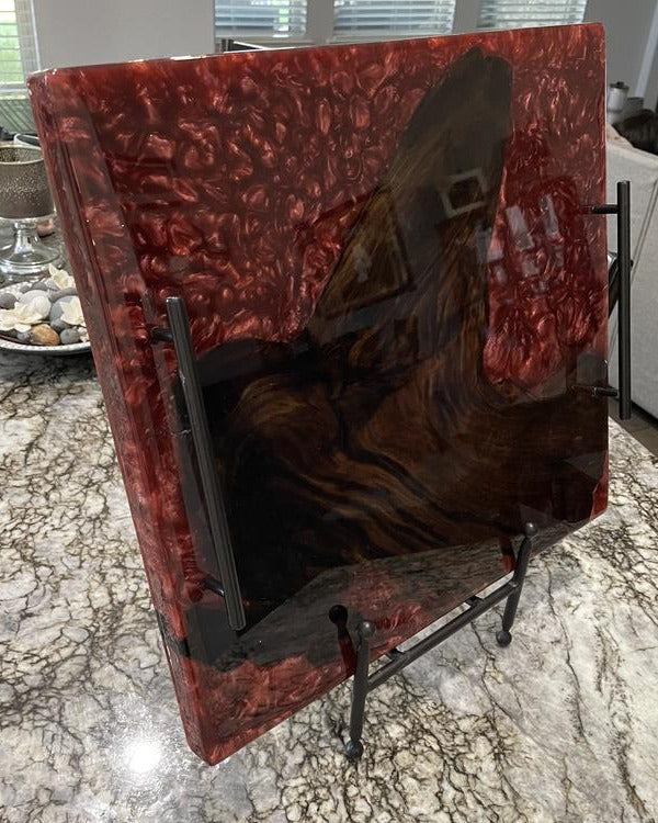 An epoxy resin tray with red pigments, resting on a stand.