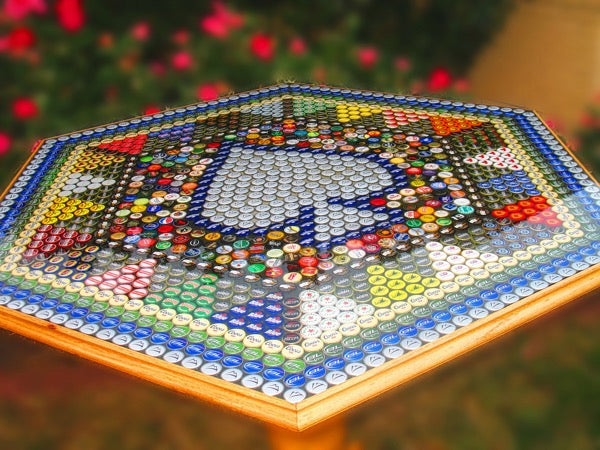A close up angled view of an epoxy bottle cap table top with a spade card suit pattern