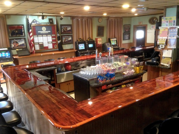 A wooden commercial bar top with an epoxy resin coating.