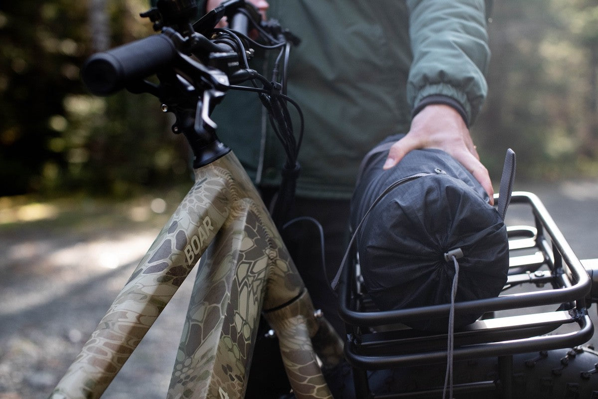 Rider placing cargo in luggage rack of Surface 604 fat tire eBike