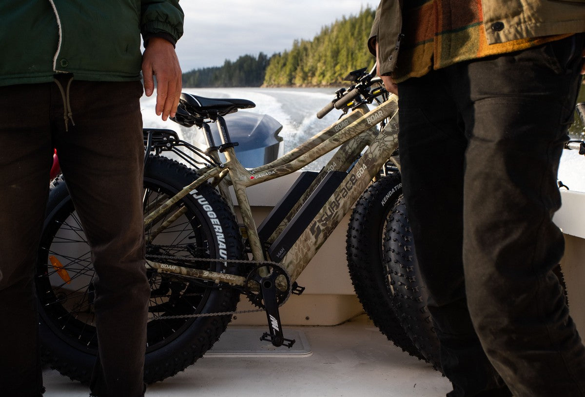 Individuals transporting Surface 604 eBikes on a boat