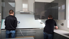painted glass splashback being installed in a kitchen