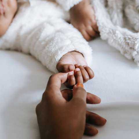 baby holding mom finger