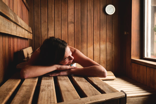 Woman lying on sauna bench