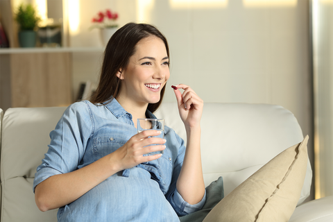pregnant woman taking a DHA supplement