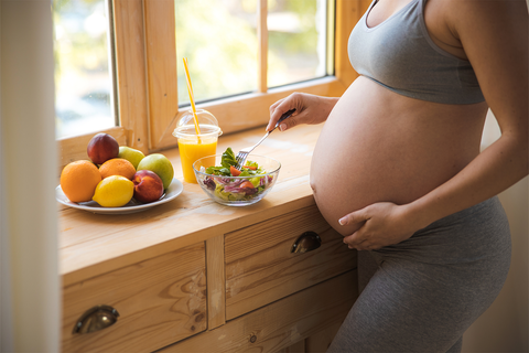 Pregnant woman eating a salad