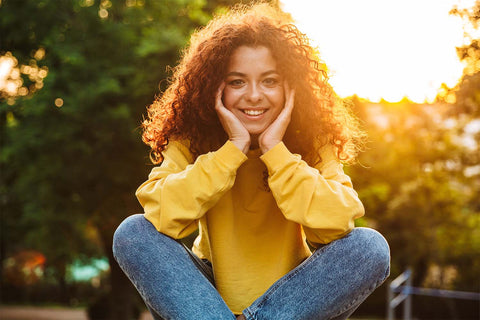 Smiling woman holding her hands to her face