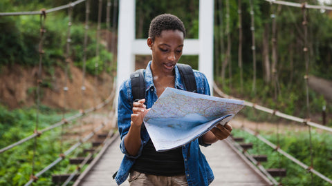 Woman hiking outdoors using a map to plan a route