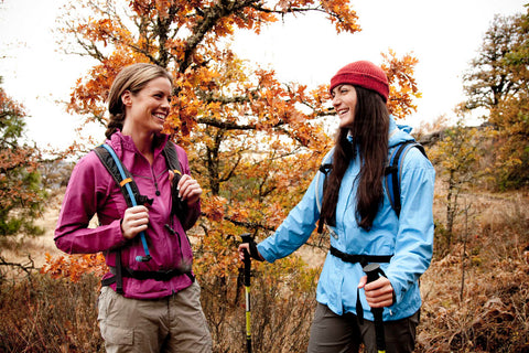 Two women smiling while hiking in nature