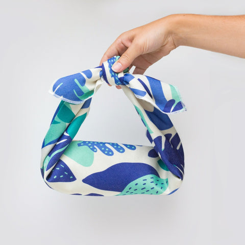 holding a blue furoshiki wrapping a book