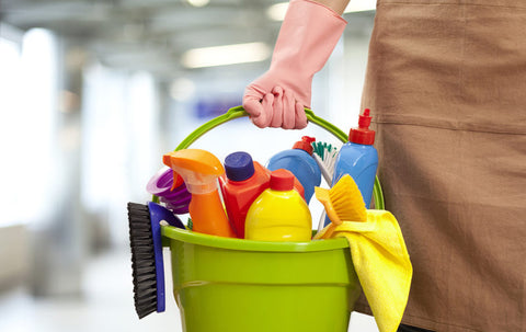 pessoa segurando um balde com produtos de limpeza