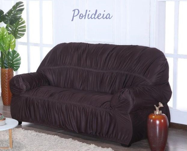Uma foto de um sofá de dois lugares coberto por uma capa cinza clara com almofadas coloridas.