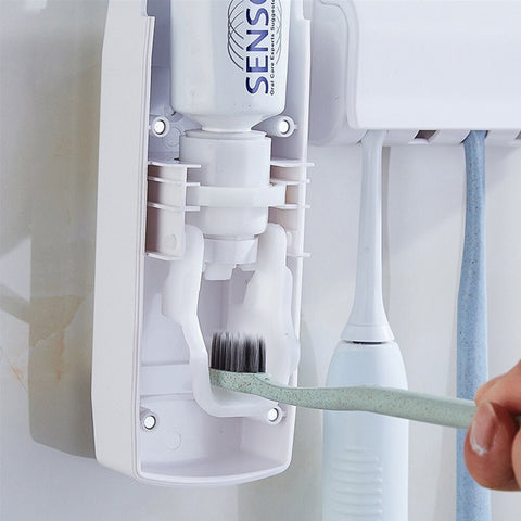 Dispenser automático de pasta de dente com suporte para escovas branco fixado na parede do banheiro com escovas de dentes coloridas