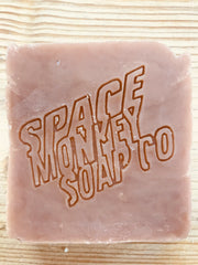light pink soap square with the text space monkey soap company pressed into the soap