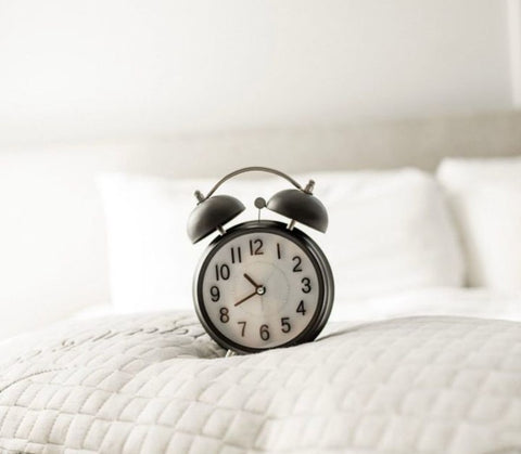 Clock on pillow to signify consistent bed times