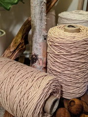 spools of macrame cord rest next to a collection of branches.