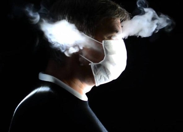 a man wearing face mask and aerosols coming out from his mask