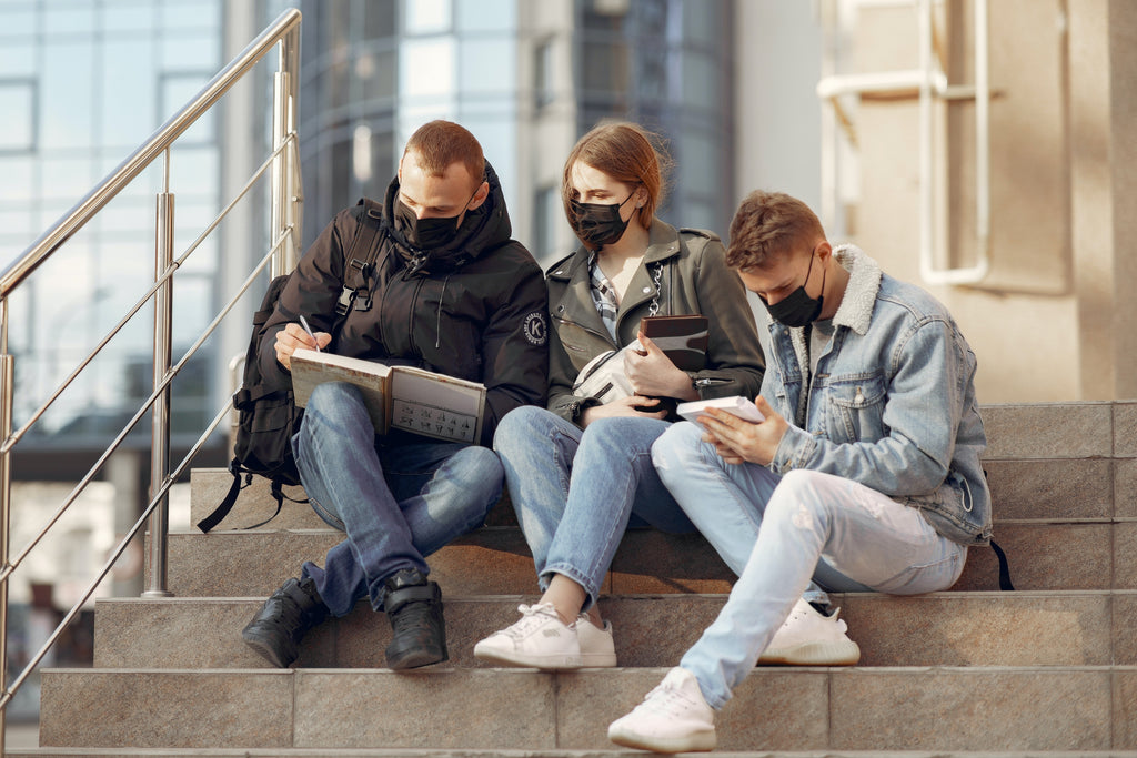 three people wearing face mask on the staircase