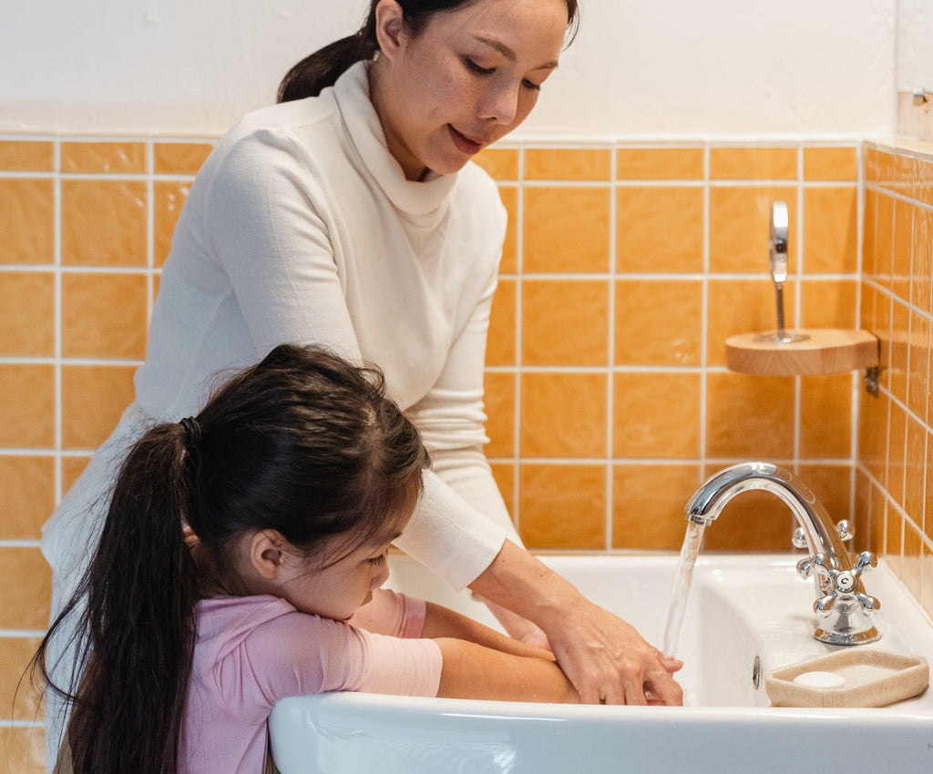 a mother and child washing hands