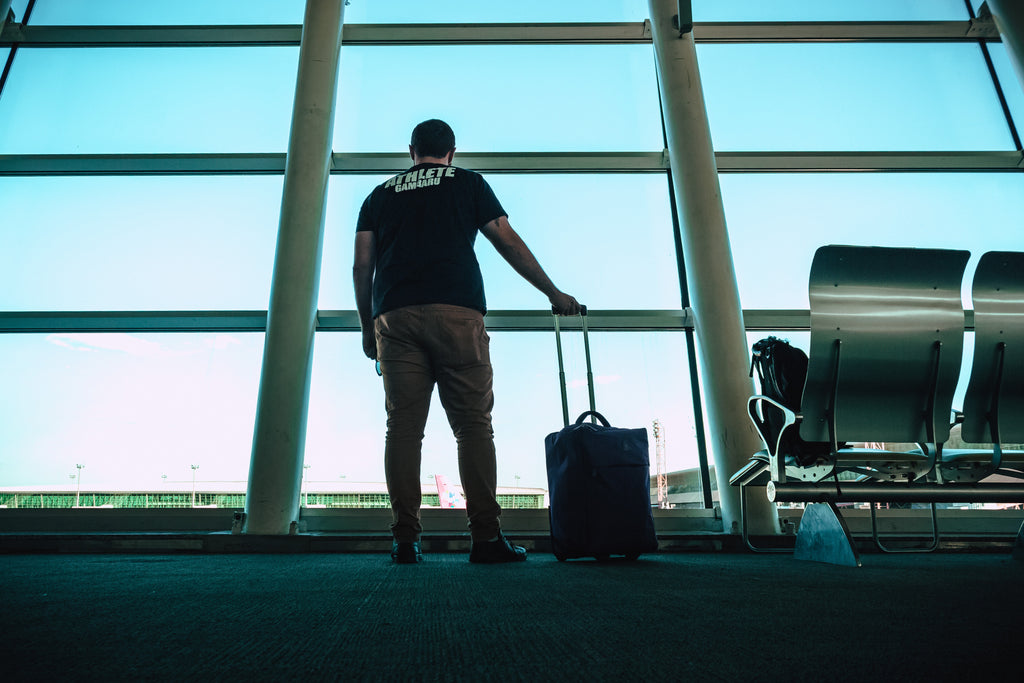 a man standing with his luggage at the airport