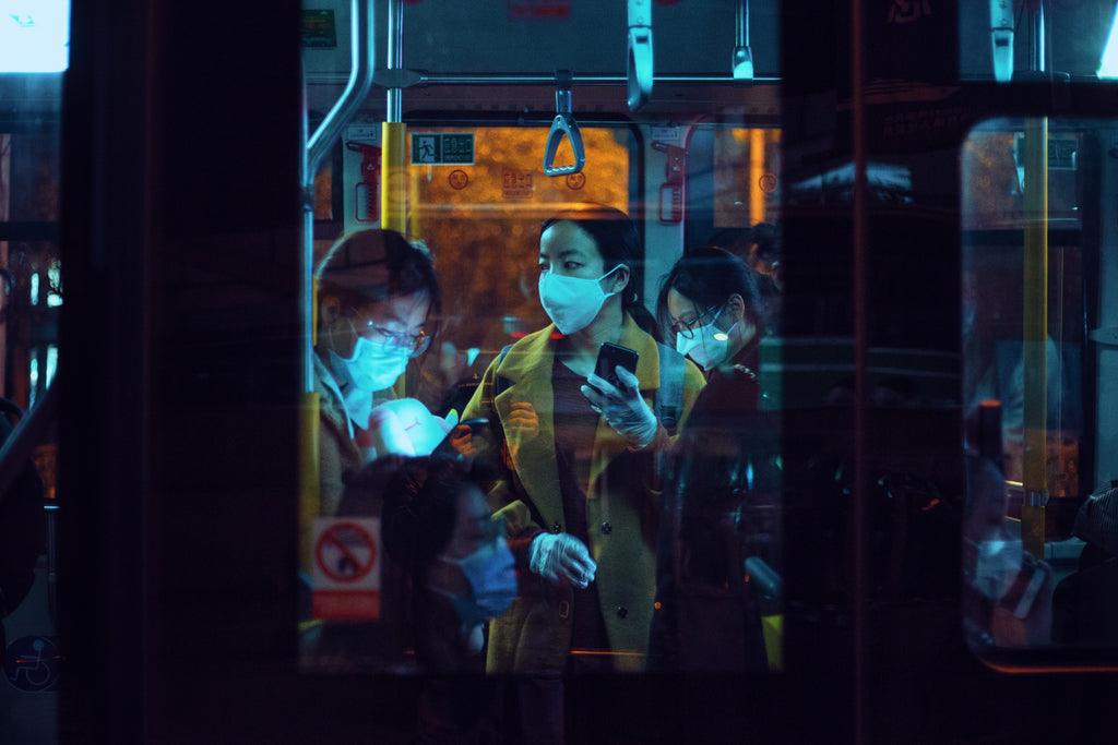 group of people on a train wearing face masks