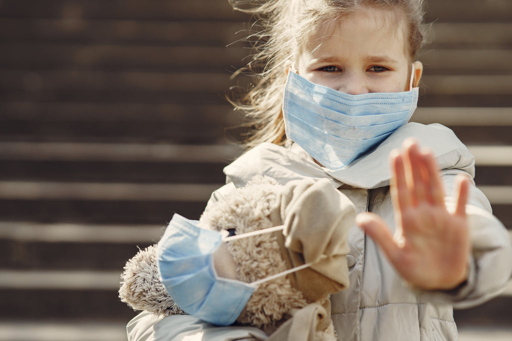 girl wearing face mask with plush toy in mask