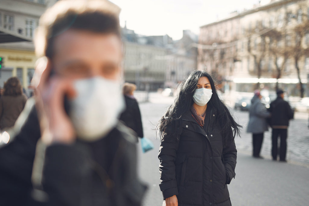 woman in black coat wearing face mask on the street