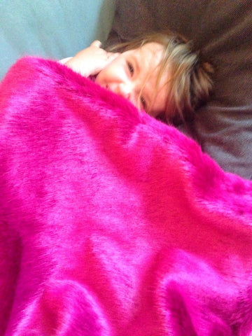 Child in a faux fur pink blanket