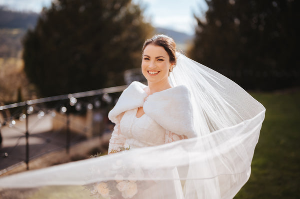 bride wears faux fur shouder wrap and veil